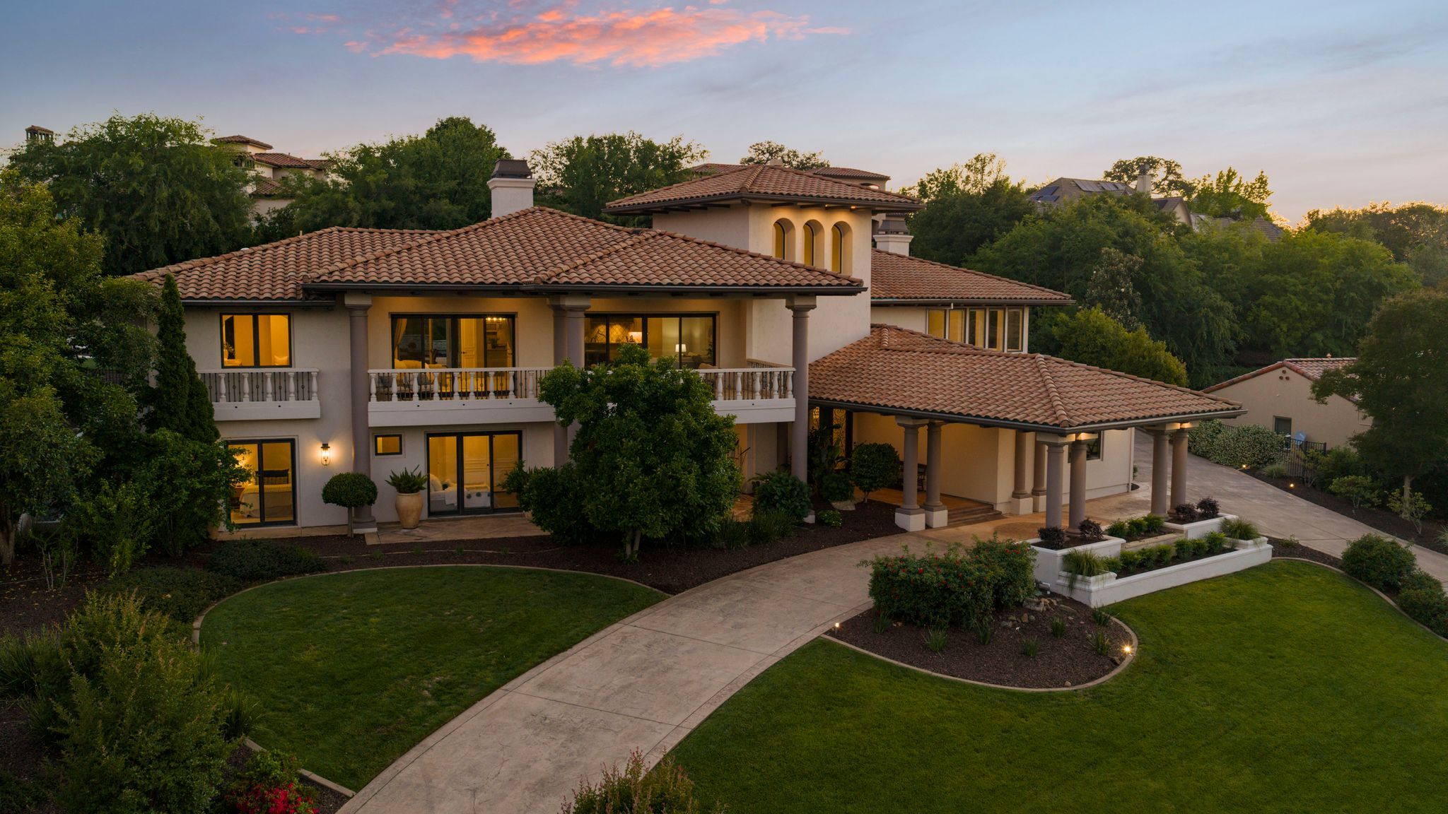 Vista del Prato at twilight, lights on, with the front walk leading to the entry